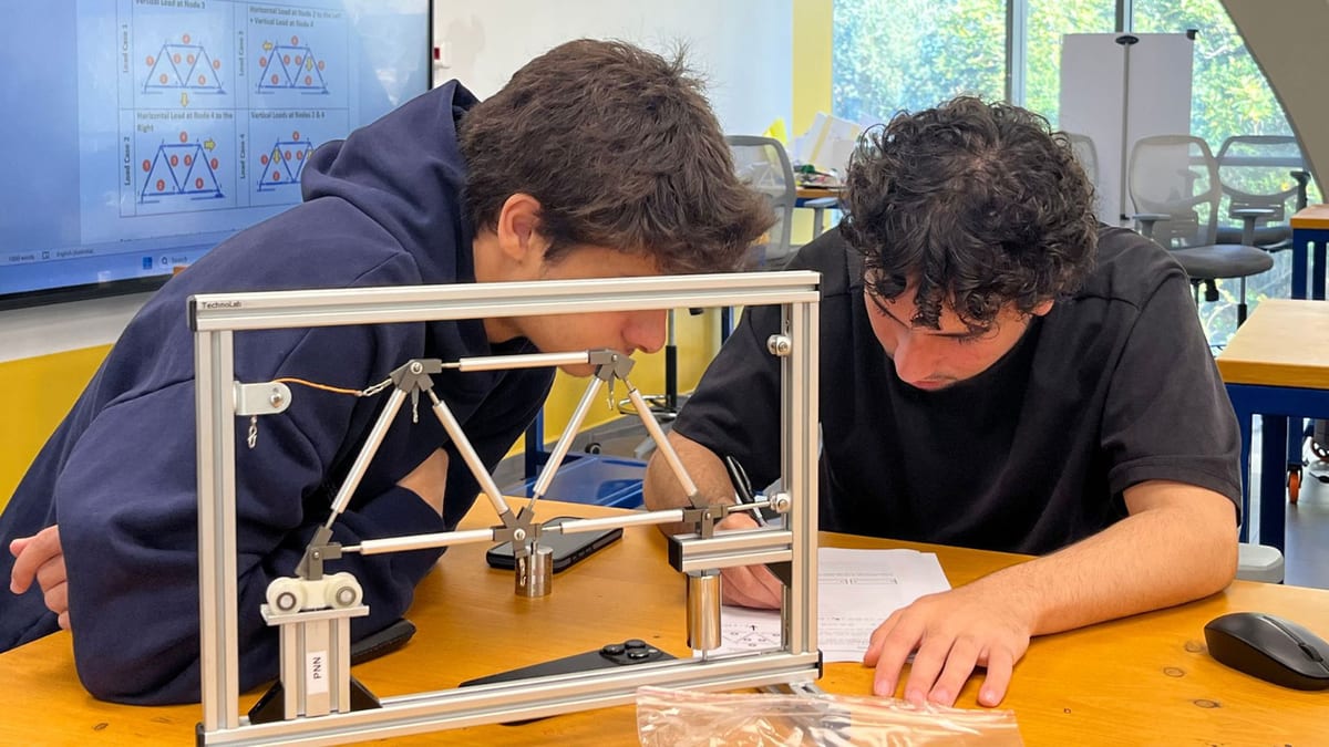 Civil engineering students examine a structural mechanics model.