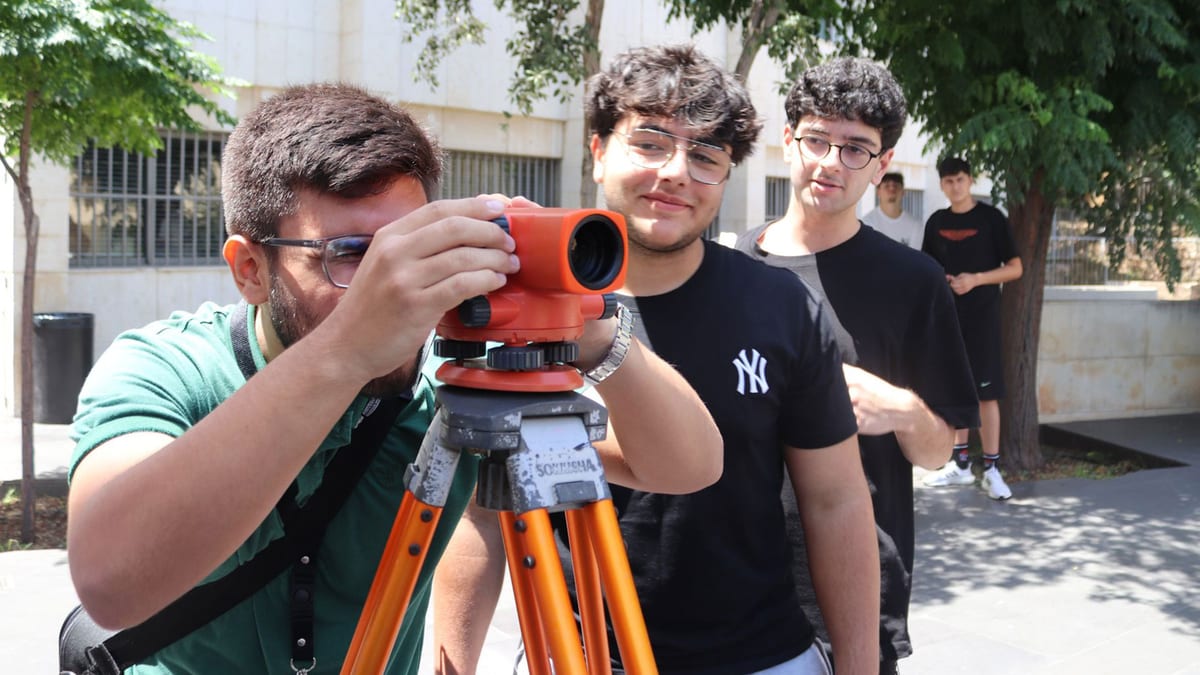 Civil engineering students carry out a surveying exercise outdoors.