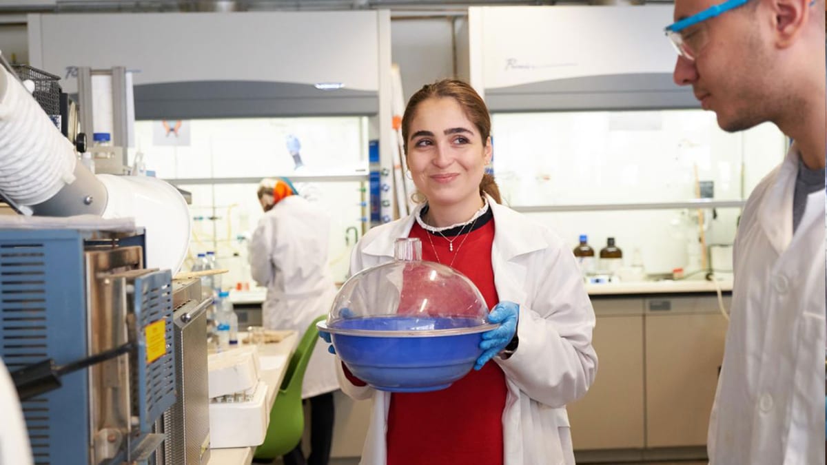 Chemical engineering students work together around laboratory process equipment.