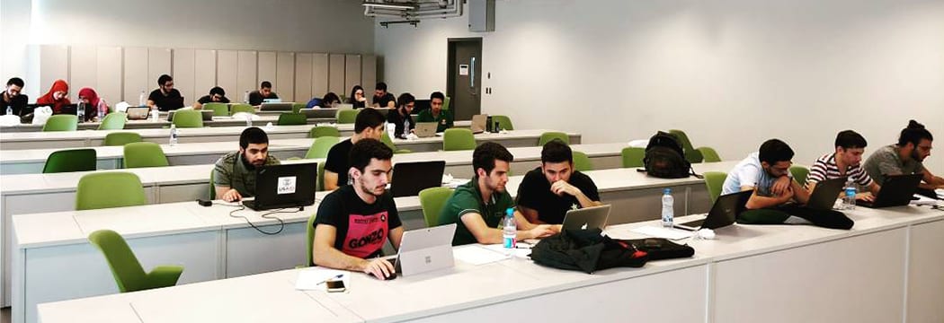 Electrical and computer engineering students work together with laptops in a classroom.