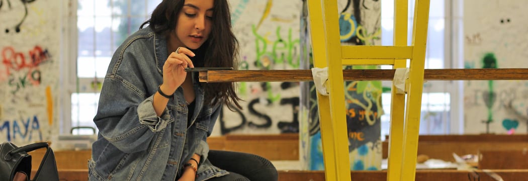 A design student works on a physical model in an architecture studio.