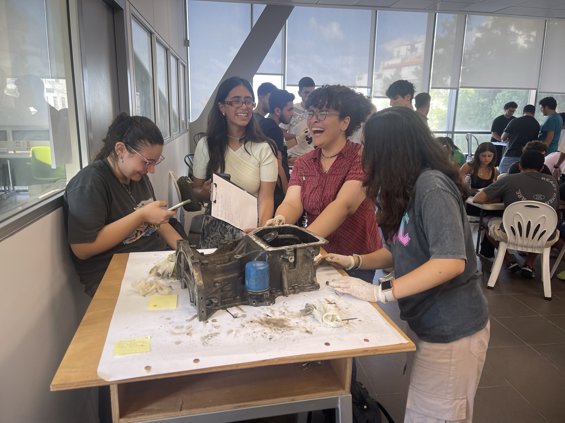 MSFEA students collaborate around a mechanical assembly during a hands-on team project.